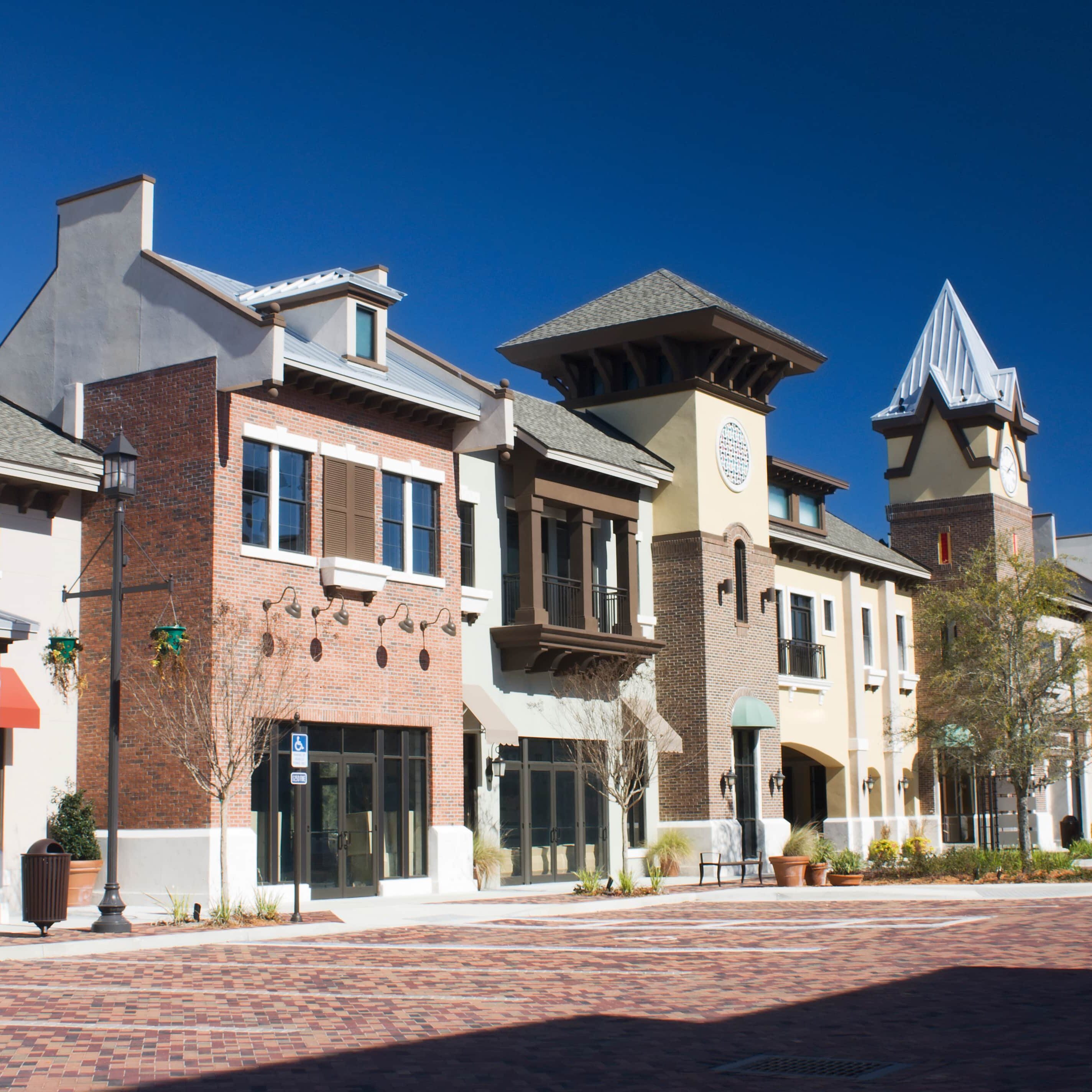 mixed architecture styles commercial strip mall with brick paver parking