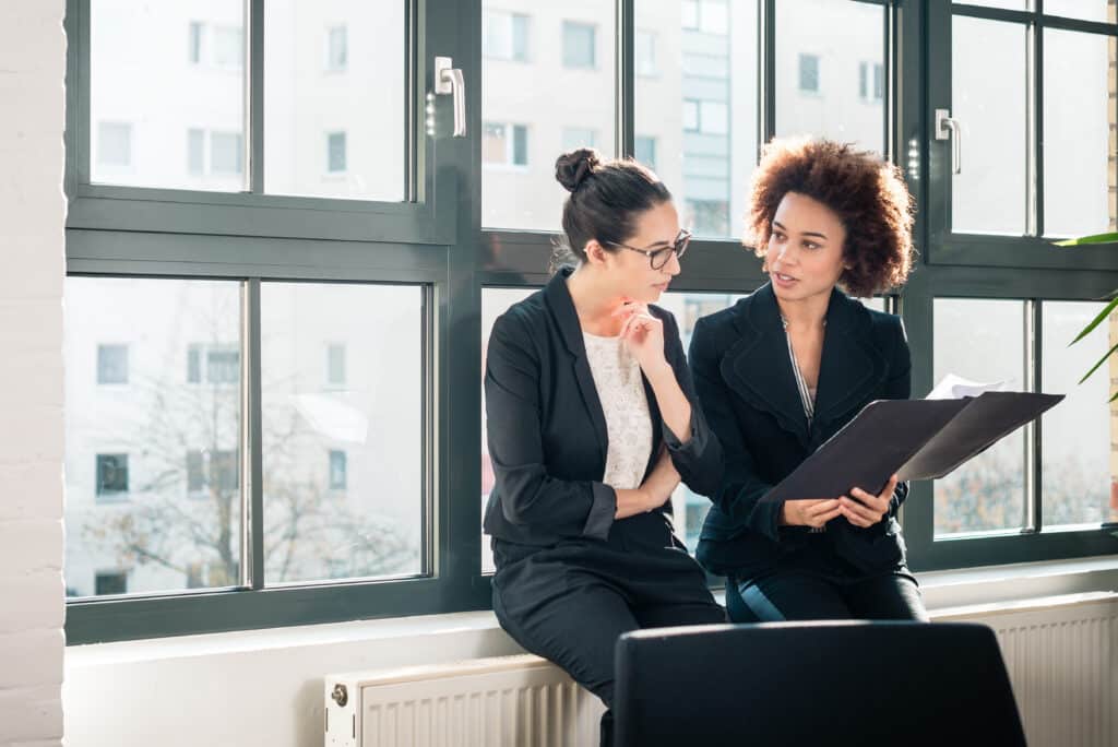 Two young property manager women reviewing resident survey results during break