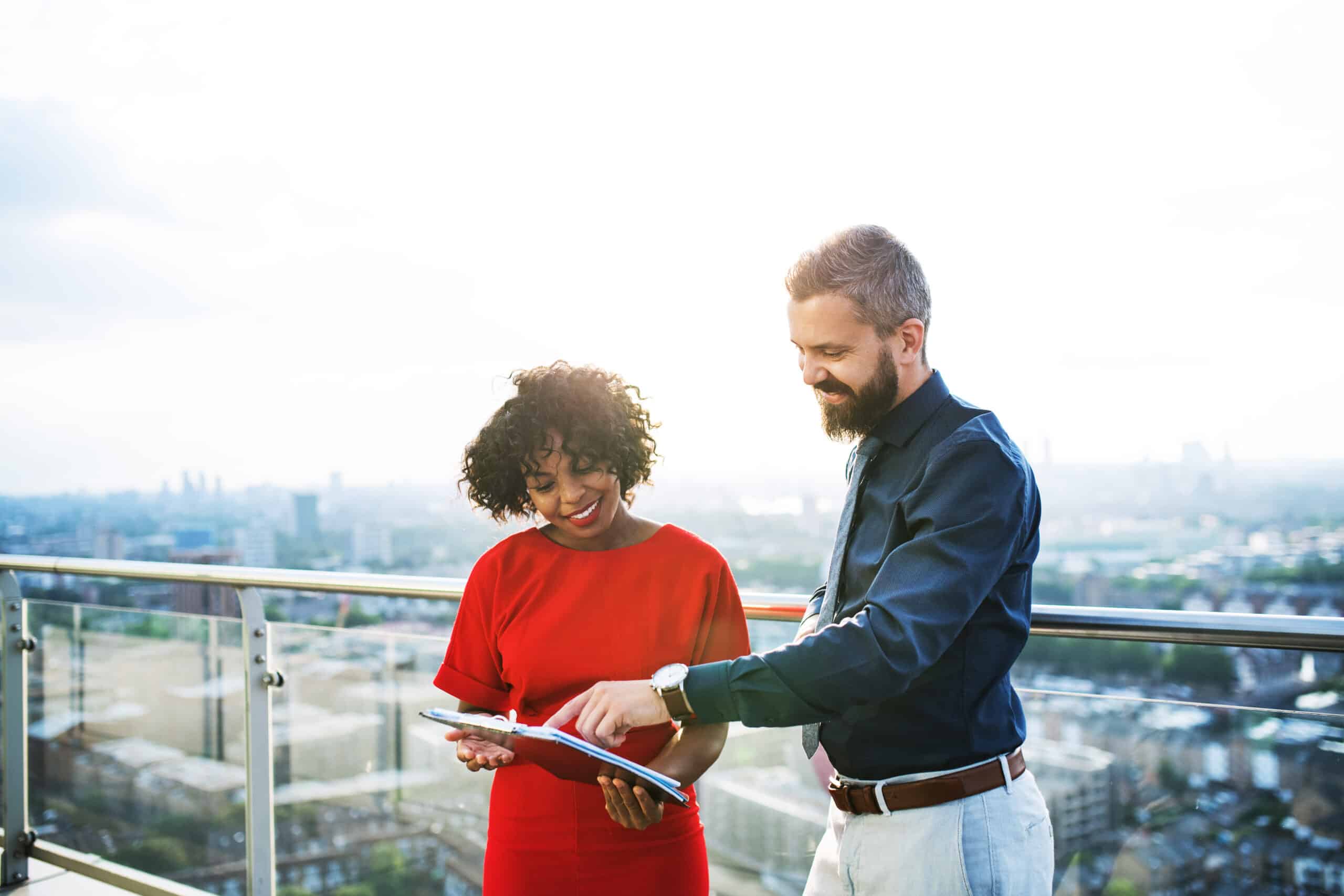 A portrait of a tenant and property manager standing against London view panorama