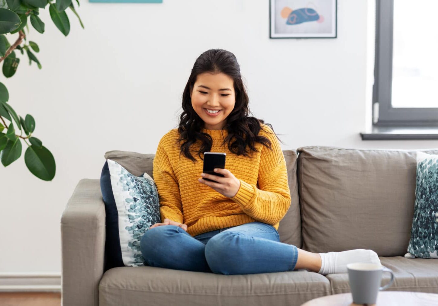 multifamily marketing woman, happy asian checking google reviews on smartphone at home