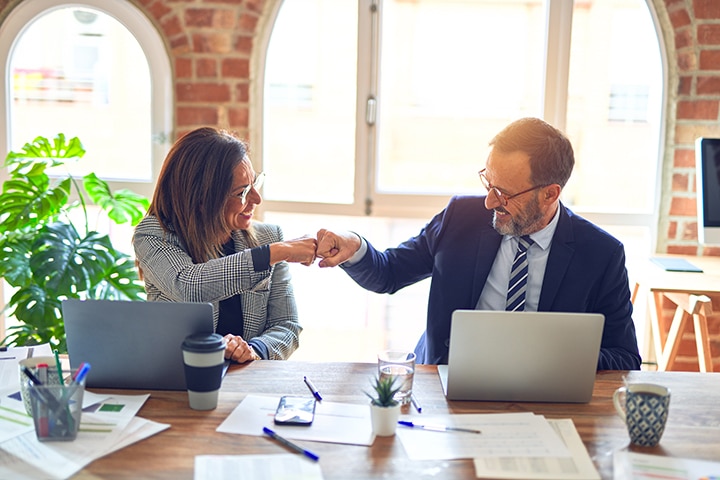Two middle age multifamily leaders smiling happy and confident.