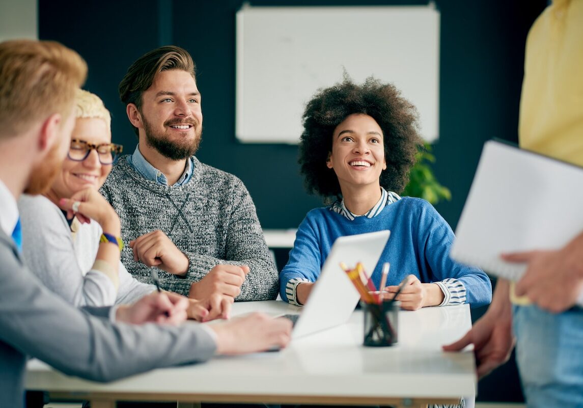 Multi ethnic team having presentation/ meeting in modern office